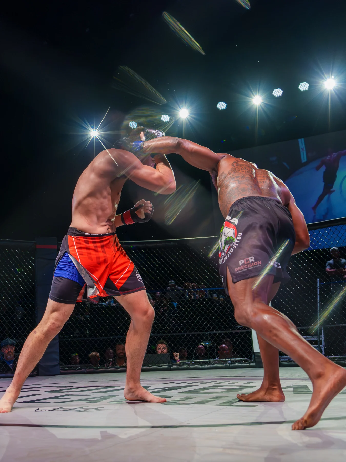 Ethan Riley and Terry Wiggins exchanging strikes under the cage lights at OCL 45