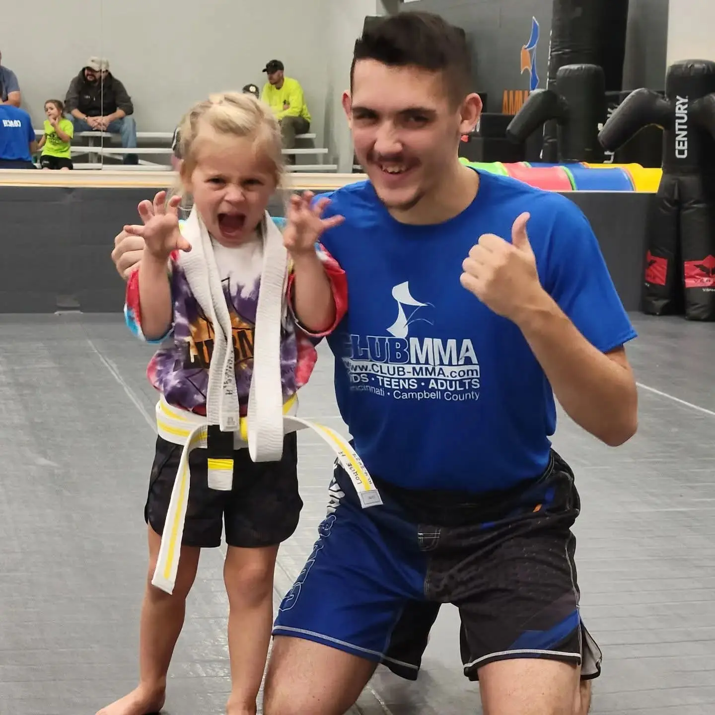 Ethan Riley beside a young martial arts student celebrating a belt milestone